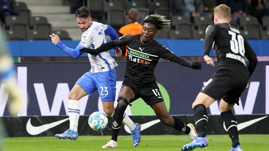 Manu Kone (M.) von Borussia Mönchengladbach im Zweikampf mit Berlins Marco Richter (l.) im Bundesliga-Topspiel am Samstag (23. Oktober 2021) im Olympiastadion. Elvedi rechts beobachtet.