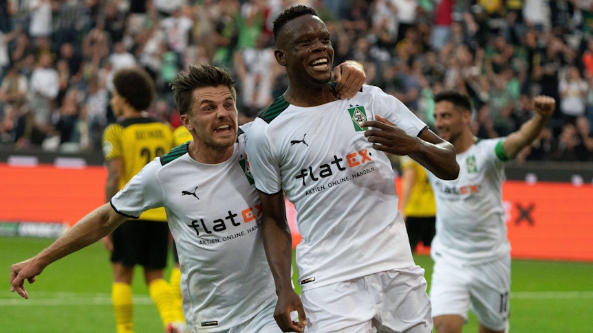 Nationalspieler Jonas Hofmann (l.) bejubelt mit Torschütze Denis Zakaria (r.) den Siegtreffer von Borussia Mönchengladbach im Bundesliga-Duell gegen Borussia Dortmund am 25. September 2021 im Borussia-Park. Hofmann nimmt Zakaria in den Arm, beide blicken Richtung Publikum.