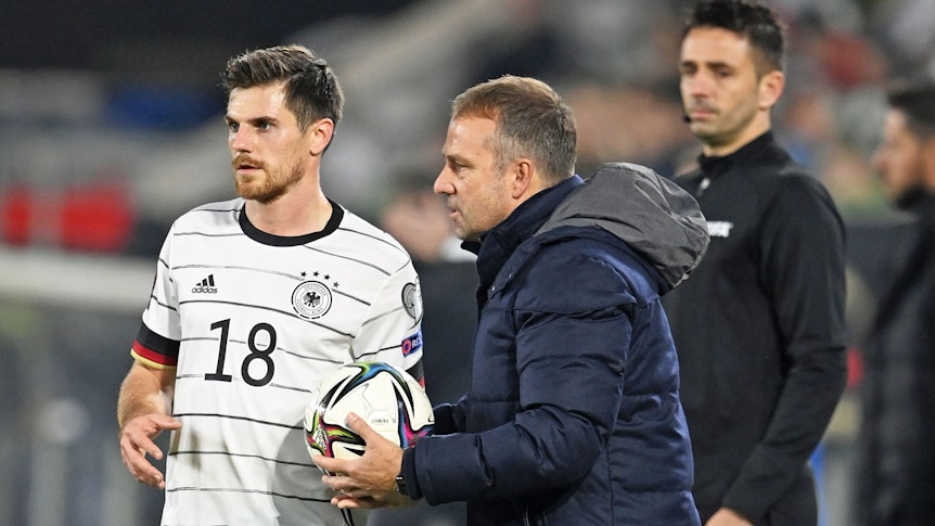Jonas Hofmann von Borussia Mönchengladbach (l.) im Trikot der Deutschen Nationalmannschaft mit Bundestrainer Hansi Flick. Das Bild stammt vom Länderspiel Deutschland gegen Liechtenstein am 11. November 2021 in Wolfsburg. Hofmann hält den Ball zum Einwurf in der Hand, Flick gibt ihm Anweisungen.