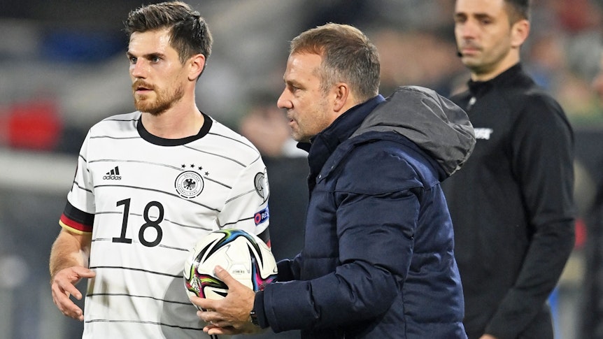 Nationalspieler Jonas Hofmann (l.) von Borussia Mönchengladbach gemeinsam mit Bundestrainer Hansi Flick (M.). Dieses Foto stammt vom 11. November 2021. Flick hält einen Ball in den Händen.