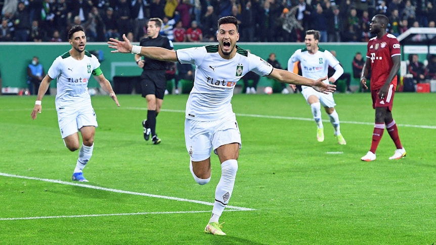 Ramy Bensebaini (M.) jubelt über einen seiner beiden Treffer für Borussia Mönchengladbach beim 5:0-Sieg gegen Rekordmeister Bayern München im DFB-Pokal am 27. Oktober 2021 im Borussia-Park. Bensebaini hat die Arme ausgebreitet und schreit seine Freude heraus.