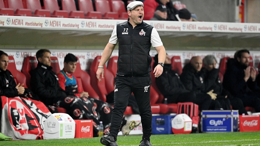 Steffen Baumgart, Trainer des Bundesligisten 1. FC Köln. Auf diesem Foto ist der Fußballlehrer am 21. November 2021 beim Spiel in Mainz zu sehen. Baumgart trägt eine Mütze und schreit etwas auf das Spielfeld.