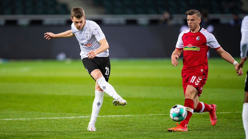 Matthias Ginter (l.), Verteidiger von Borussia Mönchengladbach. Auf diesem Foto ist der DFB-Nationalspieler im Bundesliga-Spiel gegen den SC Freiburg am 3. April 2021 zu sehen. Ginter spielt einen Pass.