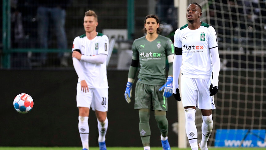 Nico Elvedi, Yann Sommer und Denis Zakaria (v.l.n.r.) von Borussia Mönchengladbach laufen mit enttäuschten Gesichtern vom Platz am 5. Dezember 2021.