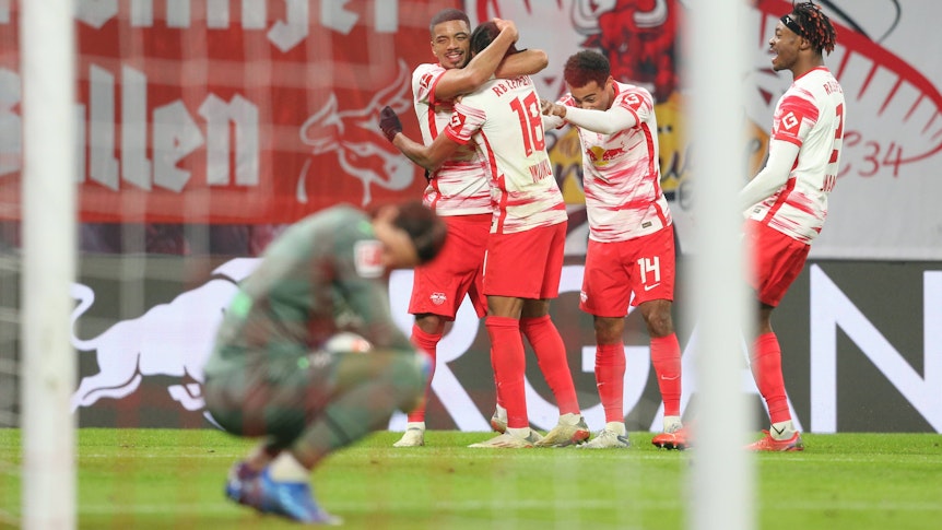 Gladbach-Torhüter Yann Sommer am Boden, derweil jubeln die Spieler von RB Leipzig über einen Treffer im Bundesliga-Duell am 11. Dezember 2021. Ein Foto mit Symbolcharakter für die sportliche Krise der Fohlen-Elf in diesen Tagen. Sommer blickt in der Hocke niedergeschlagen auf den Boden.Trag