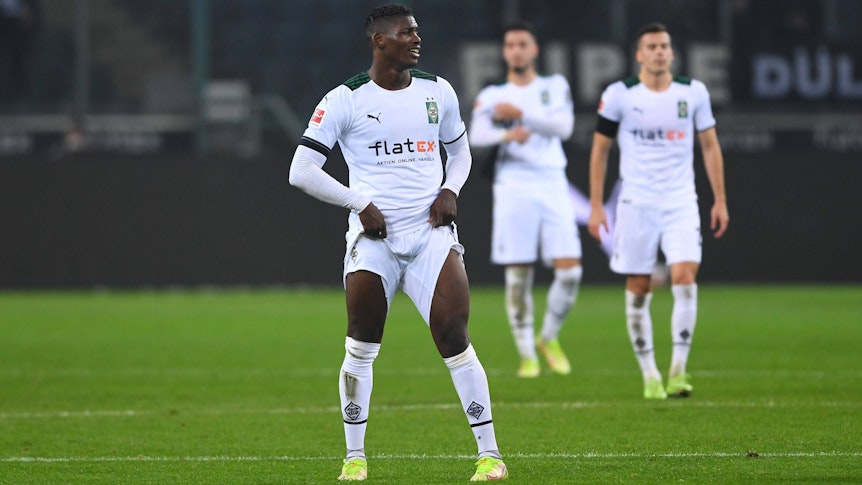 Gladbach-Stürmer Breel Embolo im Bundesliga-Duell mit Eintracht Frankfurt am Mittwoch (15. Dezember 2021). Im Hintergrund sind Laszlo Benes und Ramy Bensebaini zu sehen. Embolo zieht an seiner Hose.