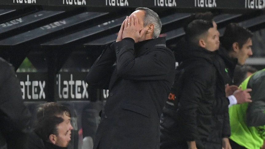 Gladbach-Trainer Adi Hütter hält sich während der Niederlage gegen Eintracht Frankfurt im Borussia-Park (15. Dezember 2021) die Hände vor das Gesicht.