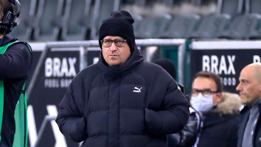 Max Eberl, Sportdirektor von Borussia Mönchengladbach, hat die Hände in den Jackentaschen und läuft mit ernstem Blick an der Seitenlinie im Spiel der Gladbacher gegen Eintracht Frankfurt am 16. Dezember 2021.