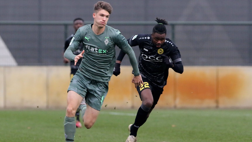 Tom Gaal (l.) von Borussia Mönchengladbach im Laufduell mit Mamodou Lamin Jallow (r.) vom VfB Homberg am 11. Dezember 2021.
