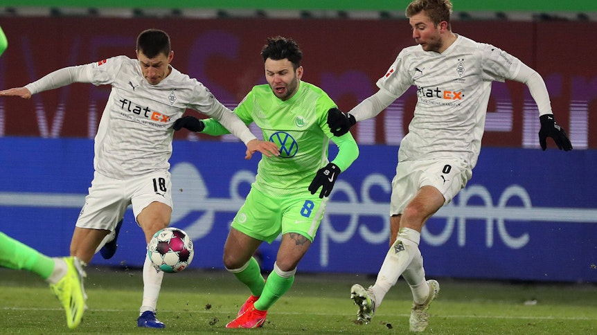Borussia Mönchengladbach, hier Stefan Lainer (l) und Christoph Kramer (r) im Zweikampf mit Renato Steffen, trennte sich im Sonntagsspiel 0:0 vom VfL Wolfsburg.