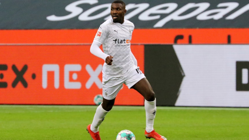 Gladbach-Stürmer Marcus Thuram, hier am 19. Dezember 2020 im Bundesliga-Duell gegen Hoffenheim zu sehen, blickt auf das Spielfeld und kontrolliert derweil den Ball.
