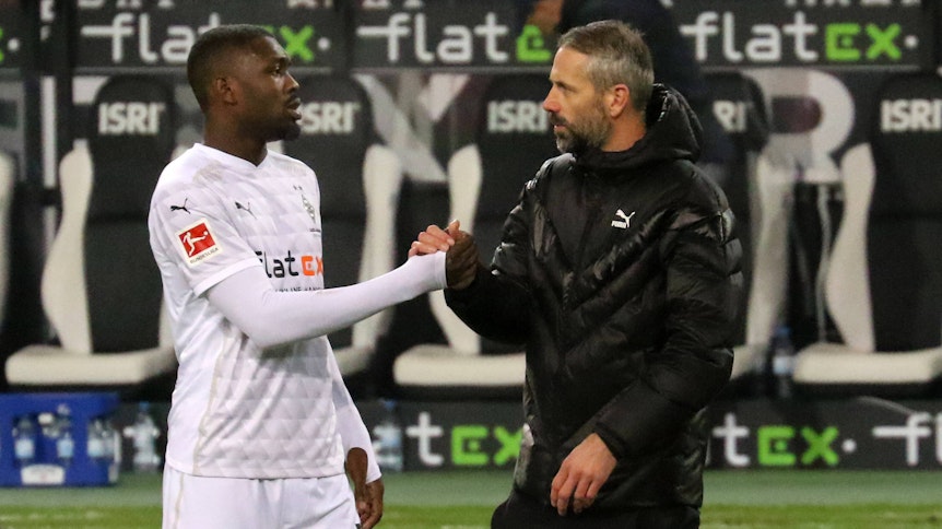 Gladbach-Stürmer Marcus Thuram (l.) und Trainer Marco Rose (r.) klatschen sich am 12. Dezember 2020, beim Bundesliga-Duell gegen Hertha BSC, an der Seitenlinie im Borussia-Park ab.