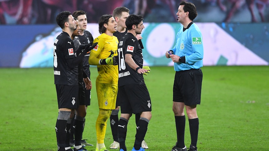 Die Borussia-Spieler Bensebaini, Plea, Neuhaus, Stindl, Sommer und Ginter beschweren sich nach dem Leipziger Siegtreffer in der Nachspielzeit des Bundesliga-Topspiels (27. Februar 2021) bei Schiedsrichter Manuel Gräfe (r.).