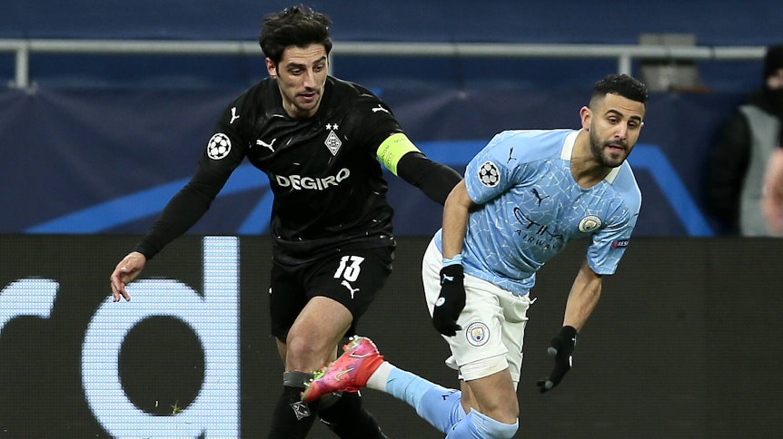 Gladbach-Kapitän Lars Stindl (l.) im Kampf um den Ball mit Riyad Mahrez (r.) von Manchester City beim Achtelfinal-Rückspiel in der Champions League am 16. März 2021 in Budapest.