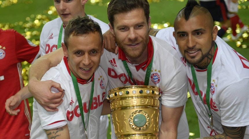 Xabi Alonso in der Mitte mit Rafinha (l.) und Arturo Vidal (r.) zeigen den DFB-Pokal nach dem Pokalfinale der Bayern gegen den BVB im Berliner Olympiastadion am 21. Mai 2016.