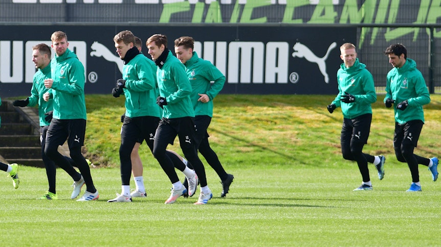 Teile der Gladbacher Mannschaft beim Warmlaufen für das Training im Borussia-Park am 15. März 2021.