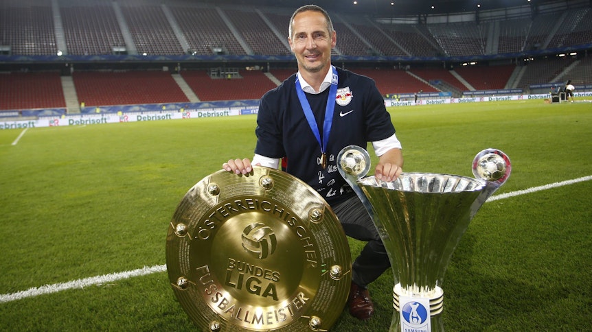 Adi Hütter posiert am 3. Juni 2015 mit der Meisterschale und dem Pokal, die er mit dem FC Red Bull Salzburg 2015 geholt hat.