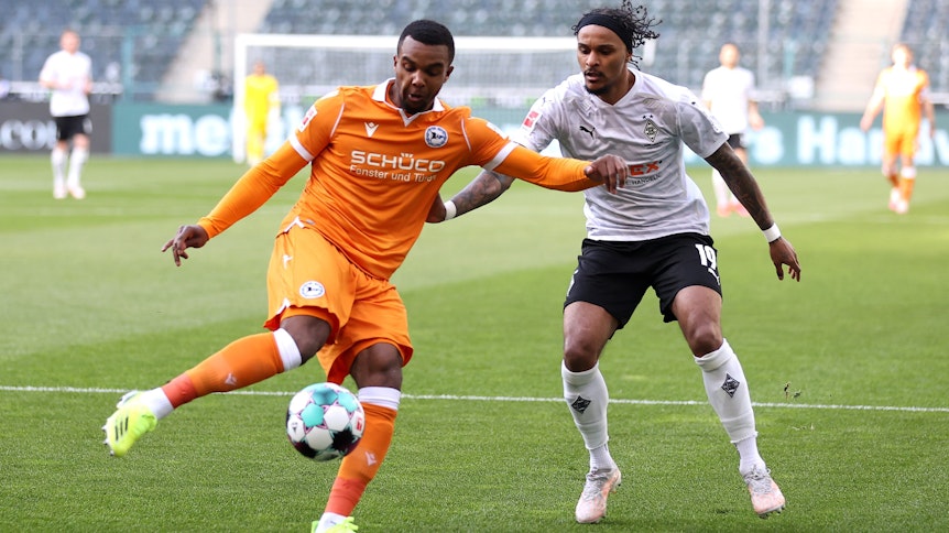 Gladbachs Valentino Lazaro (r.) kämpft gegen Nathan de Medina (l.) um den Ball im Bundesligaspiel der Borussia gegen Arminia Bielefeld am 25. April 2021.