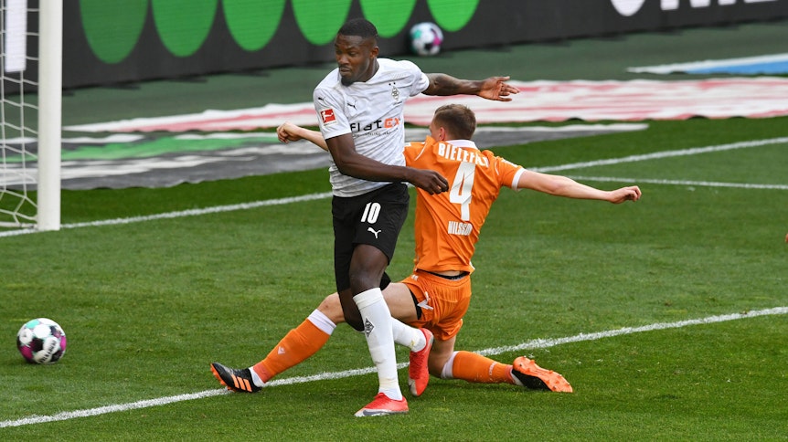 In dieser Szene trifft Gladbach-Stürmer Marcus Thuram (l.) im Bundesliga-Duell gegen Arminia Bielefeld am 25. April 2021 ins gegnerische Tor. Joakim Nilsson (r.) kommt zu spät.
