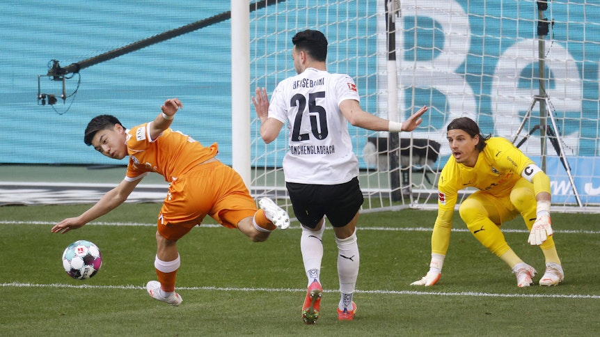 Torhüter Yann Sommer (r.) von Borussia Mönchengladbach schaut im Bundesligaspiel gegen Arminia Bielfeld am 25. April 2021 genau zu beim Zweikampf zwischen Rami Bensebaini (M.) und Ritsu Doan (l.).