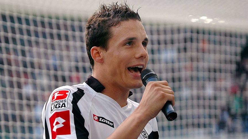 David Degen im Trikot der Gladbacher Borussia. Dieses Foto entstand am 14. Oktober 2006 und zeigt Degen vor der Nordkurve im Borussia-Park mit dem Stadionmikro in der Hand.