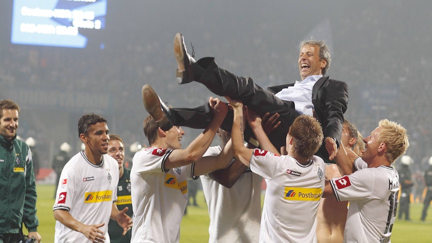Ex-Gladbach Trainer Lucien Favre wird von den Spielern auf Händen getragen nach dem Rückspiel der Relegation gegen den VfL Bochum am 25. Mai 2011.