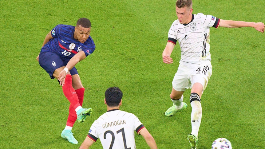 Gladbachs Nationalspieler Matthias Ginter (r.) am 15. Juni 2021 im Zweikampf mit Frankreichs Top-Stürmer Kylian Mbappé (l.). Im Vordergrund schaut DFB-Mittelfeldspieler İlkay Gündoğan zu.