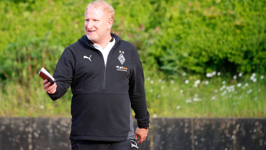 Gladbachs U23-Coach Heiko Vogel am 28. Mai 2021 beim Regionalliga-Spiel zwischen Borussias U23 und dem FC Wegberg-Beeck, lacht am Spielfeldrand.