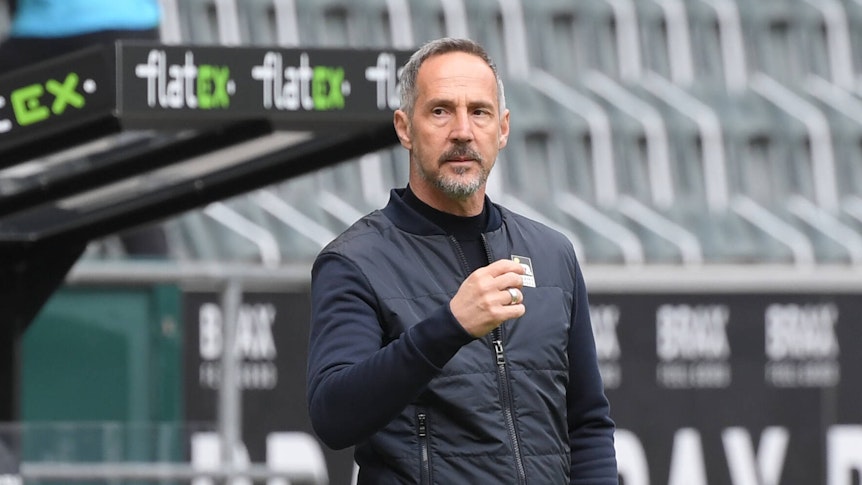 Gladbachs zukünftiger Trainer Adi Hütter hebt den rechten Arn und blickt auf das Spielfeld im Borussia-Park.