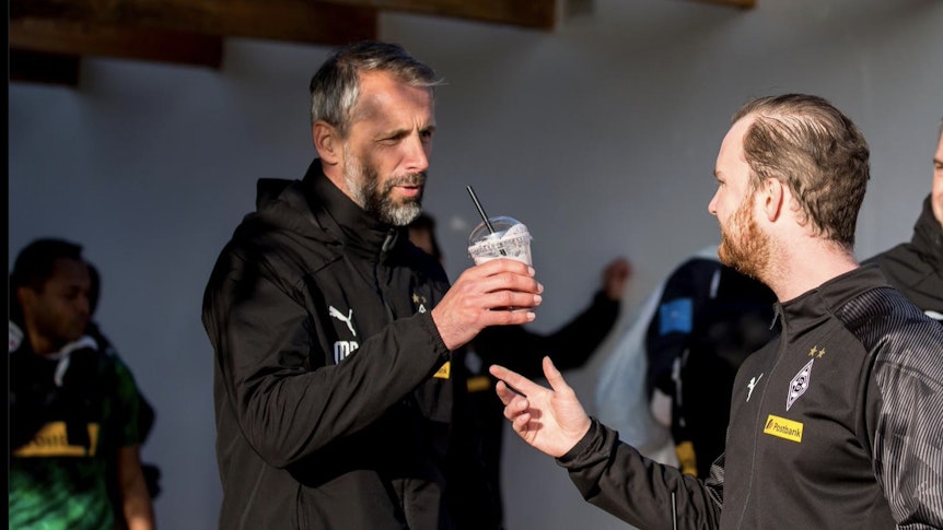 Trainer Marco Rose von Borussia Mönchengladbach bekommt nach dem Training von Melf Carstensen einen Shake gereicht.