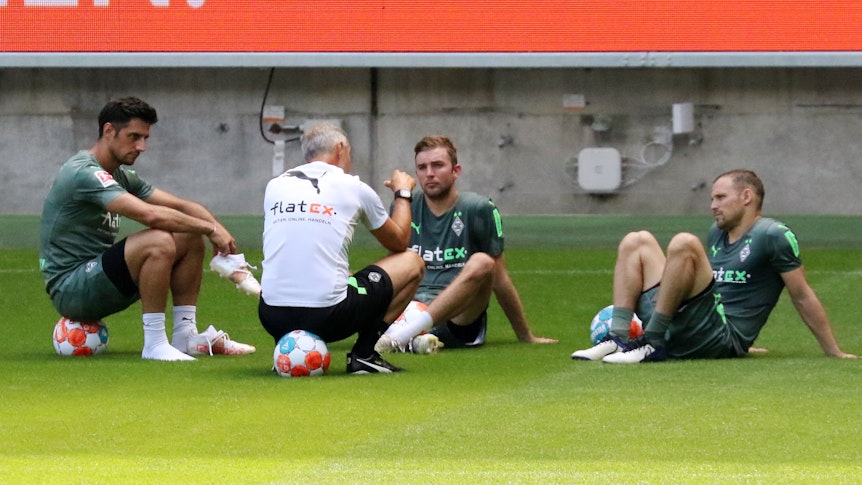 Gladbachs Christoph Kramer (Mitte) nach der Trainingseinheit am 4. Juli 2021 im Gespräch mit seinen Teamkollegen Lars Stindl (links) und Tony Jantschke (rechts) sowie Trainer Adi Hütter (vorne) im Borussia-Park.