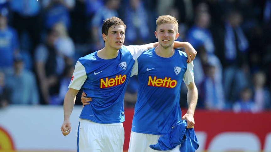 Leon Goretzka (l.) hat den Arm um Christoph Kramers Schultern gelegt, beide Fußballspieler lachen.