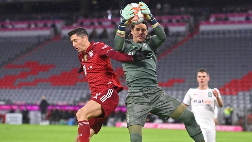 Yann Sommer (r.), Torhüter von Borussia Mönchengladbach, hält auch in dieser Szene gegen Bayern-München-Stürmer Robert Lewandowski (l.) den Rückrunden-Auftakt-Sieg (7. Januar 2022) der Fohlen-Elf in der Allianz-Arena fest. Im Hintergrund schaut Borussias Verteidiger Matthias Ginter gebannt zu.