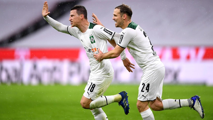 So sehen Sieger aus! Die Borussia-Mönchengladbach-Profis Stefan Lainer (l.) und Tony Jantschke (r.) beim Jubellauf während des Rückrunden-Sieges (7. Januar 2022) bei Bayern München in der Allianz-Arena. Lainer hebt den Arm voller Freude, Jantschke läuft und jubelt mit.