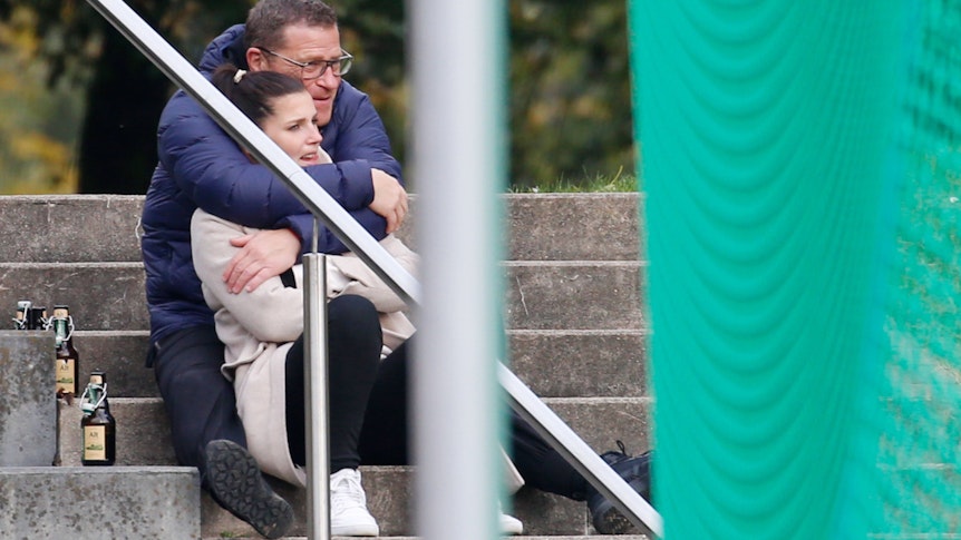 Max Eberl, Manager von Borussia Mönchengladbach, schaut sich in Viersen gemeinsam mit der ehemaligen Assistenz-Teammanagerin des VfL, Sedrina Schaller, am 17. Oktober 2021 das Landesliga-Spiel zwischen ASV Süchteln gegen SC Kapellen-Erft an. Max Eberl umarmt von hinten Sedrina Schaller.