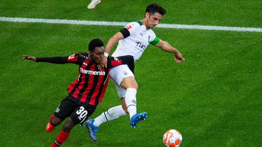 Lars Stindl (r.) von Borussia Mönchengladbach im Duell um den Ball mit Jeremie Frimpong von Bayer Leverkusen beim Bundesliga-Hinrundenspiel am 21. August 2021.