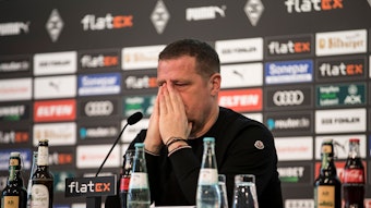 Max Eberl bei seiner Rücktritts-Pressekonferenz am 28. Januar 2022 als Sportdirektor von Fußball-Bundesligist Borussia Mönchengladbach. Inzwischen hat der 49-Jährige bei RB Leipzig angeheuert. Auf diesem Bild hält sich ein weinender Eberl die Hände vor das Gesicht.