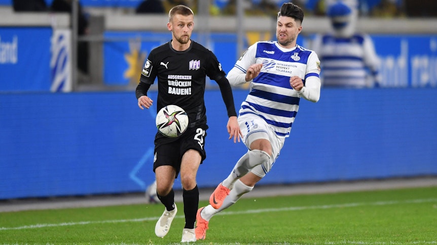 Mittelfeldspieler Sebastian Klaas (l.) von Drittligist VfL Osnabrück im Duell mit Moritz Stoppelkamp (r.) vom MSV Duisburg am 2. Februar 2022. Klaas führt den Ball.