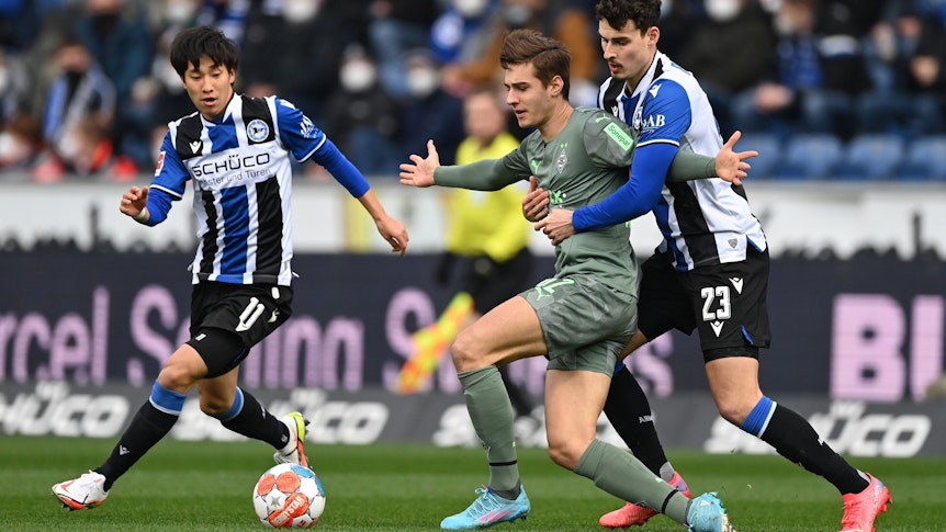 Bielefeld gegen Gladbach: Janni Serra (r.) und Florian Neuhaus (Mitte) beim Zweikampf.