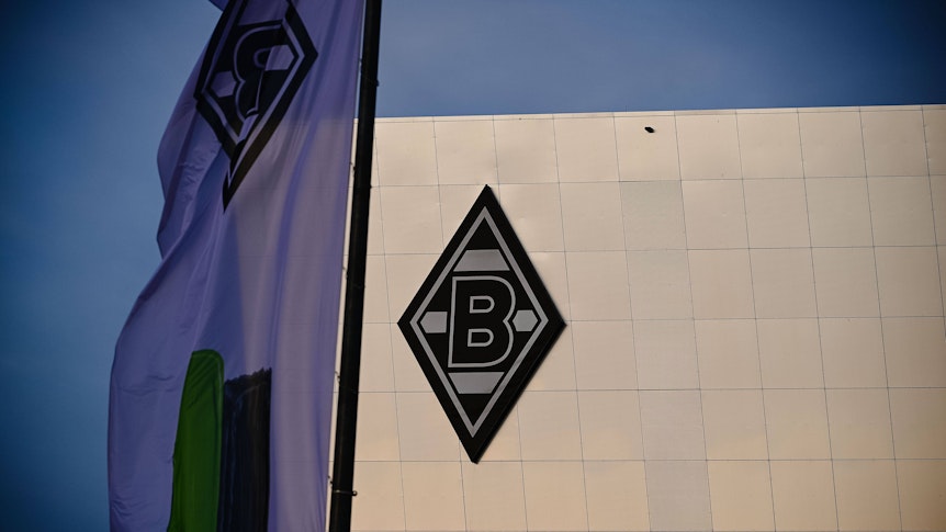 Der Borussia-Park in Mönchengladbach. Auf dem Neubau 8 Grad ist die Borussia-Raute zu sehen. Das Foto stammt vom 24. November 2020. Im Vordergrund ist eine Fahne.