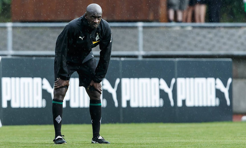 Otto Addo als Co-Trainer von Borussia Mönchengladbach während des Fohlen-Trainingslagers am 25. Juli 2018 in Rottach-Egern am Tegernsee. Addo hat sich nach vorne gebeugt und schaut über das Spielfeld.