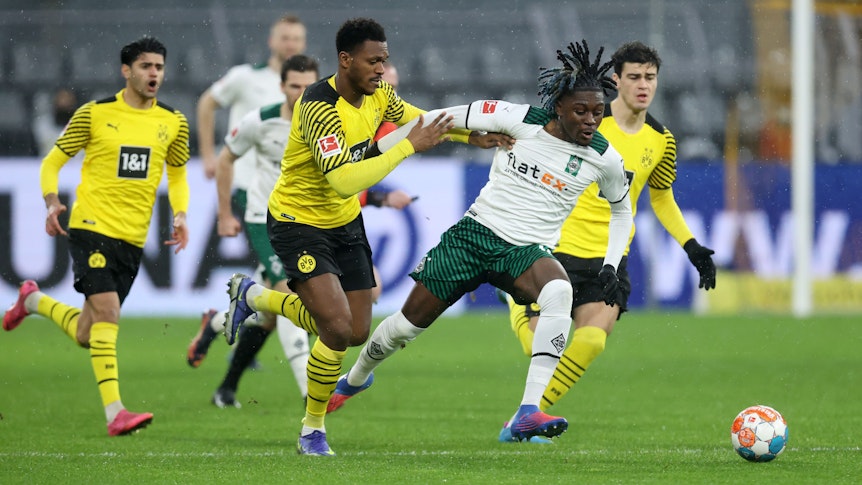 DORTMUND, GERMANY - FEBRUARY 20: Dan-Axel Zagadou of Borussia Dortmund battles for possession with Kouadio Kone of Borussia Monchengladbach during the Bundesliga match between Borussia Dortmund and Borussia Mönchengladbach at Signal Iduna Park on February 20, 2022 in Dortmund, Germany. (Photo by Alex Grimm/Getty Images)