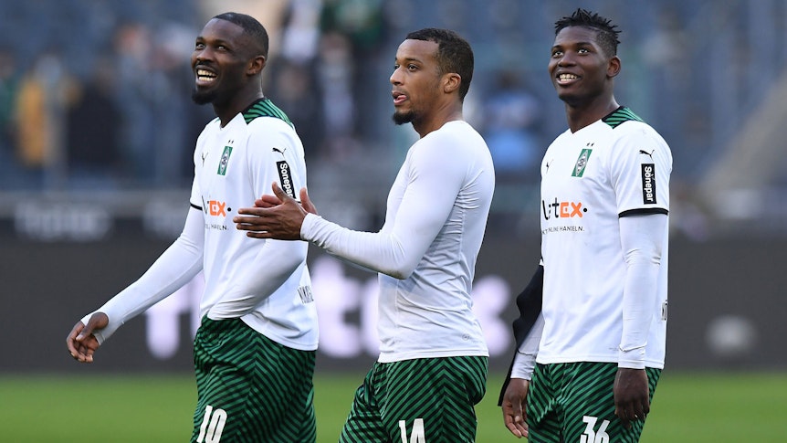 Marcus Thuram (l.), Alassane Plea (M.) und Breel Embolo (r.) unter sich: Die Stürmer von Fußball-Bundesligist Borussia Mönchengladbach haben nach dem Duell gegen Wolfsburg (26. Februar 2022) auch mal wieder lachen können. Plea klatscht in die Hände.