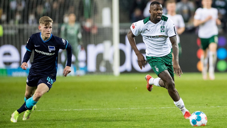 Anton Kade von Hertha BSC kommt da nicht mit! Stürmer Marcus Thuram von Borussia Mönchengladbach hat im Bundesliga-Duell (12. März 2022) gegen die Berliner einen neuen Sprint-Rekord aufgestellt. Thuram rennt mit dem Ball am Fuß davon.