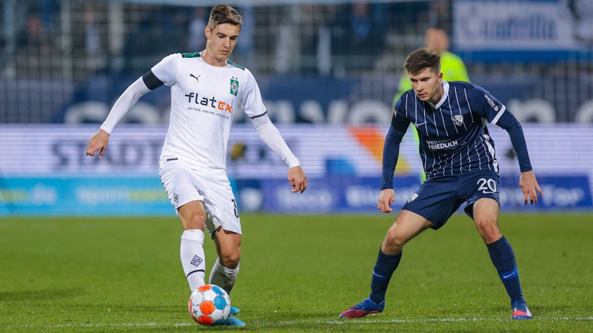 Florian Neuhaus (l.) von Borussia Mönchengladbach im Bundesliga-Duell (18. März 2022) mit Elvis Rexhbecaj (r.) vom VfL Bochum. Neuhaus hat den Ball am Fuß.