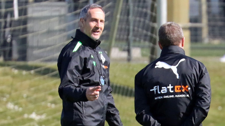 Gladbach-Trainer Adi Hütter (l.), hier zu sehen am 22. März 2022, ist nach auskurierter Coronainfektion zurück im Borussia-Park. Hütter spricht mit Co-Trainer Frank Geideck.