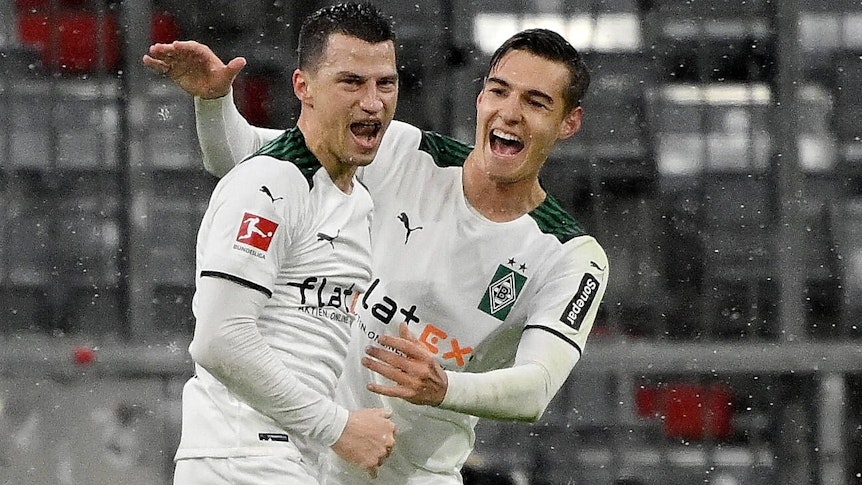 Borussia-Mönchengladbach-Verteidiger Stefan Lainer (l.) bejubelt gemeinsam mit Florian Neuhaus (r.) seinen 2:1 Treffer in der Allianz-Arena gegen den FC Bayern München. Lainer und Neuhaus brüllen ihre Freude heraus.