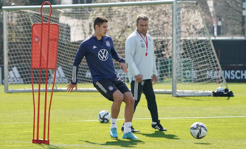 Gladbach-Profi Florian Neuhaus (l.) während einer Trainingseinheit der DFB-Elf am 22. März 2022. Bundestrainer Hansi Flick (r.) schaut genau hin.