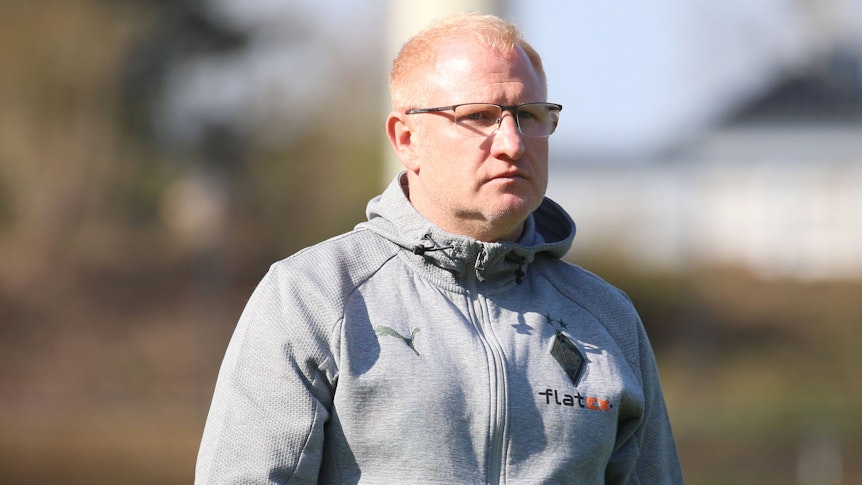 Der ehemalige Gladbach-Trainer Heiko Vogel, hier zu sehen am 26. März 2022 im Rheydter Grenzlandstadion. Vogel trägt eine Brille und schaut nach vorne.