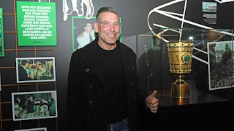 DFB-Pokalsieger und Torhüterlegende von Borussia Mönchengladbach, Uwe Kamps, in der Fohlen-Welt am 3. April 2022. Uwe Kamps steht lächelnd, mit dem linken Daumen nach oben, vor dem DFB-Pokal.